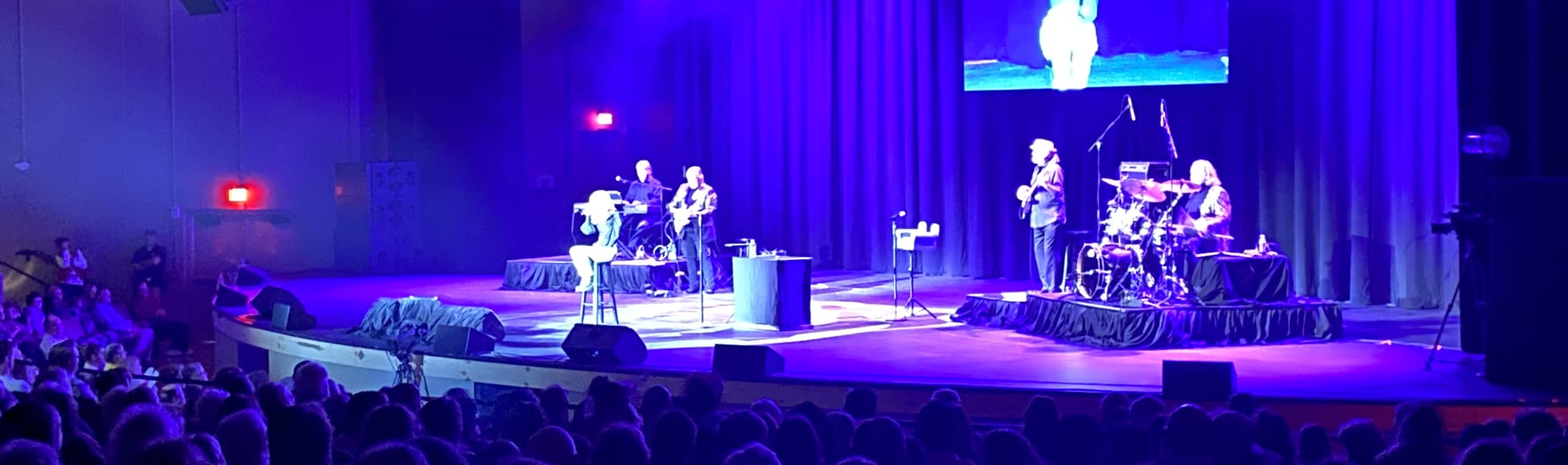 signer on stage in chair washed out by the lights New York City